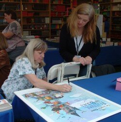 Earlene signing the festival poster