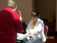 me signing for a fan at Malice Domestic. 